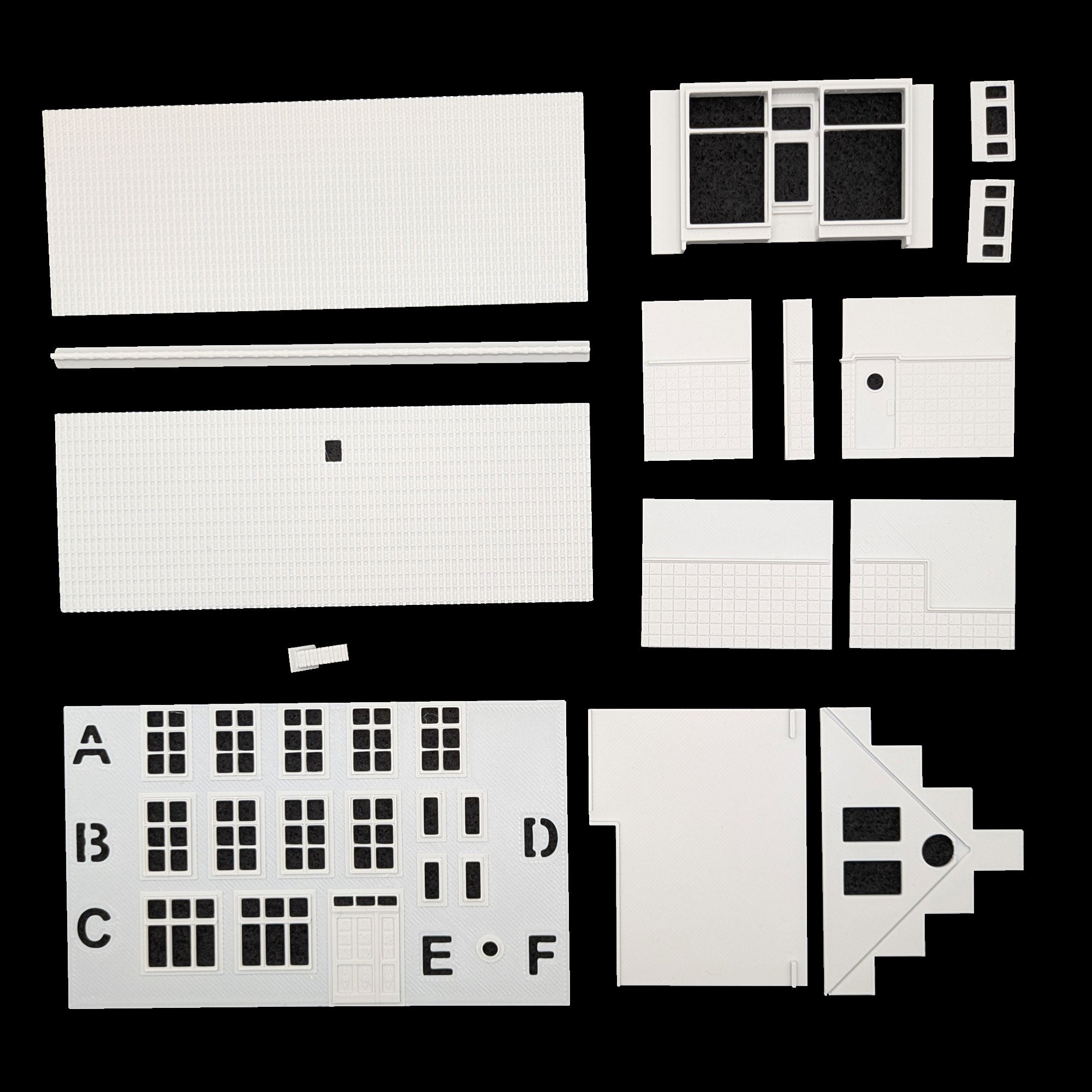 Übersicht der präzisen Einzelteile des Bausatzes: Fensterrahmen, Türen und Fassadenelemente für TT.