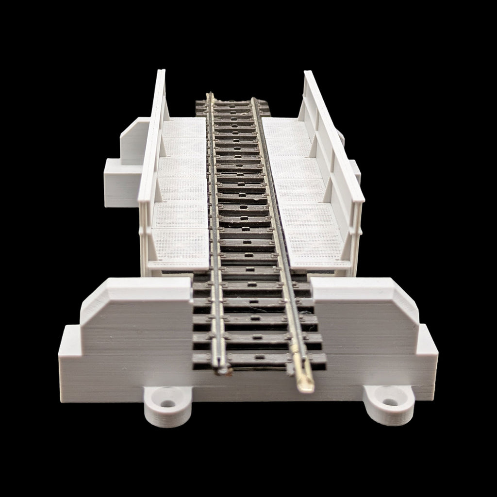 Blick entlang der Schienen auf der eingleisigen H0 Trogbrücke, zeigt die präzise Gitterstruktur des Bodens.