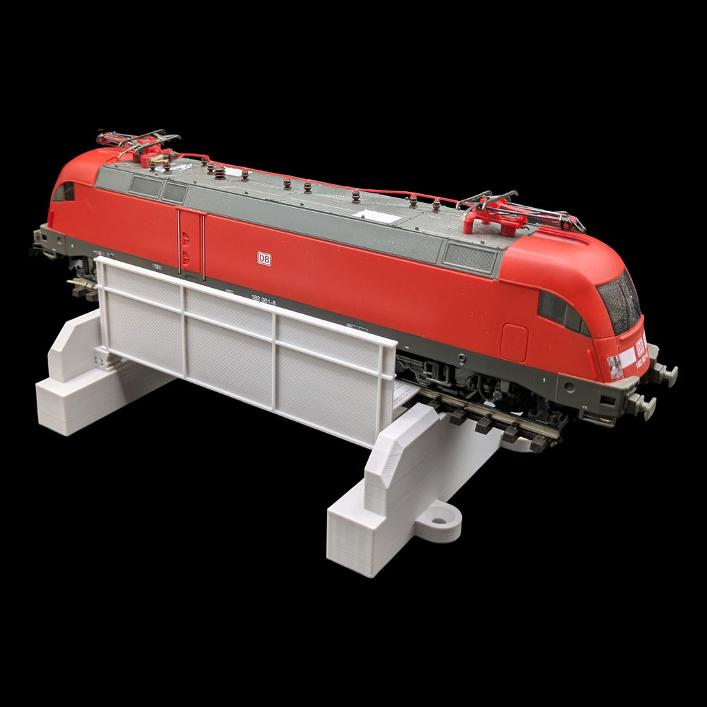 Funktionsbeispiel der H0 Trogbrücke mit einer roten DB BR 182 Elektrolokomotive zur Veranschaulichung der Größe.